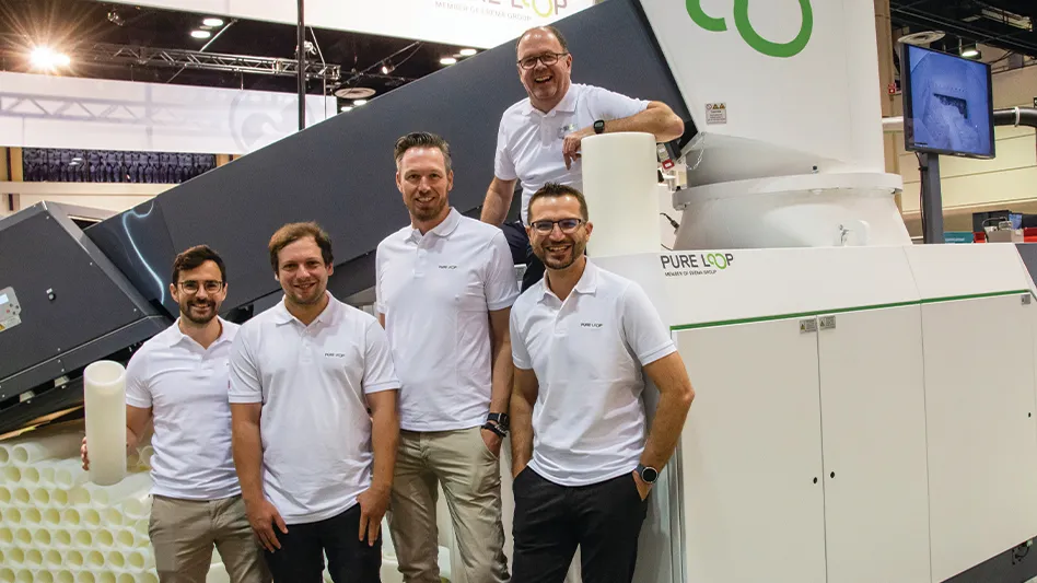 Members of the Pure Loop team pose in front of an ISEC evo 302 plastic recycling machine at the NPE 2024 convention in Orlando.