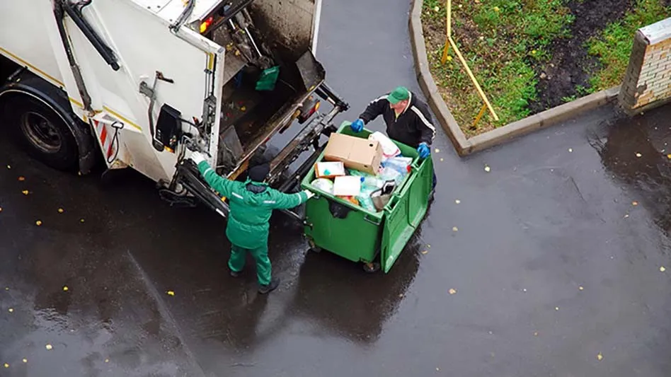 Waste and recycling workers by garbage truck
