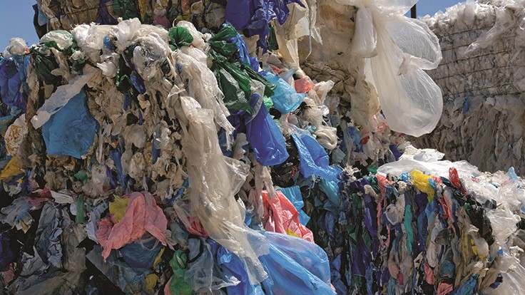 bales of plastic bags stacked against a blue sky