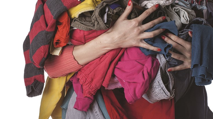 woman holding a bunch of clothes