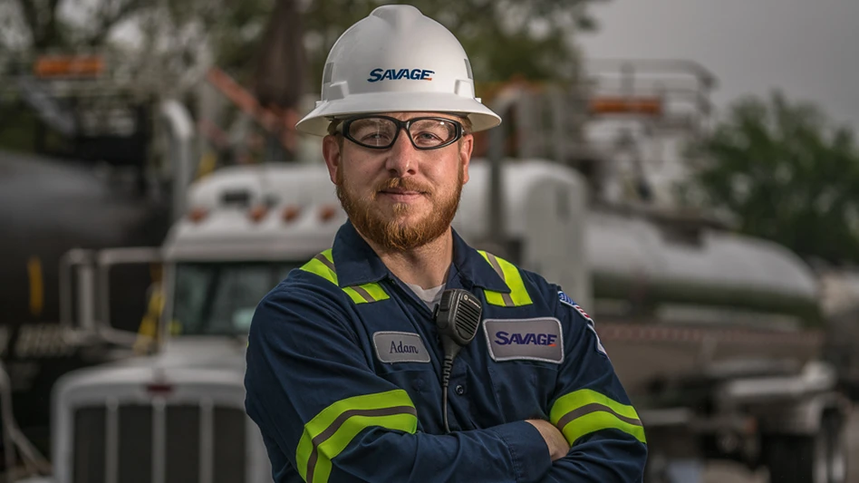 A Savage worker posing in front of a truck