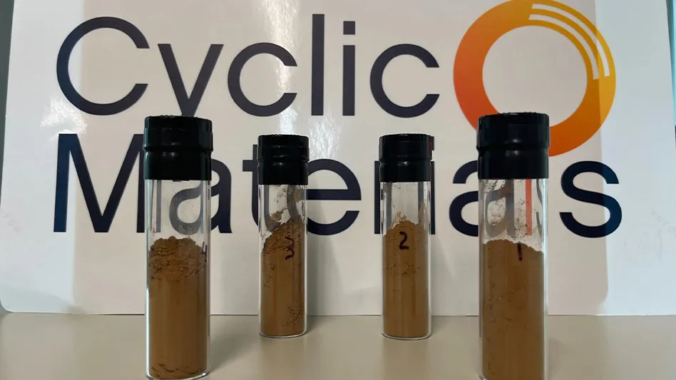 Vials of mixed rare earth oxide samples recycled by Cyclic Materials, with the company logo in the background.