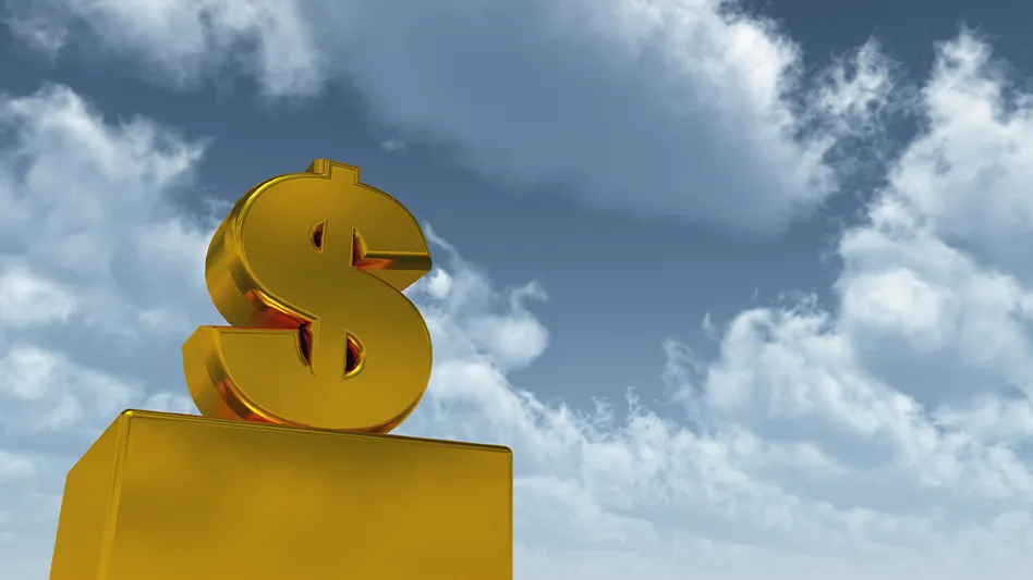 A gold dollar sign on a gold pedastal in front of a blue sky and clouds.