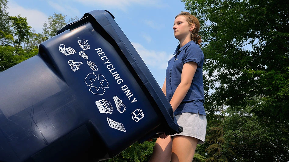 a girl wheeling a recycling cart outdoors
