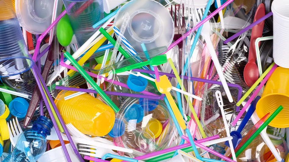 A colorful pile of single-use plastic products, ranging from plates to cups, straws and cutlery.