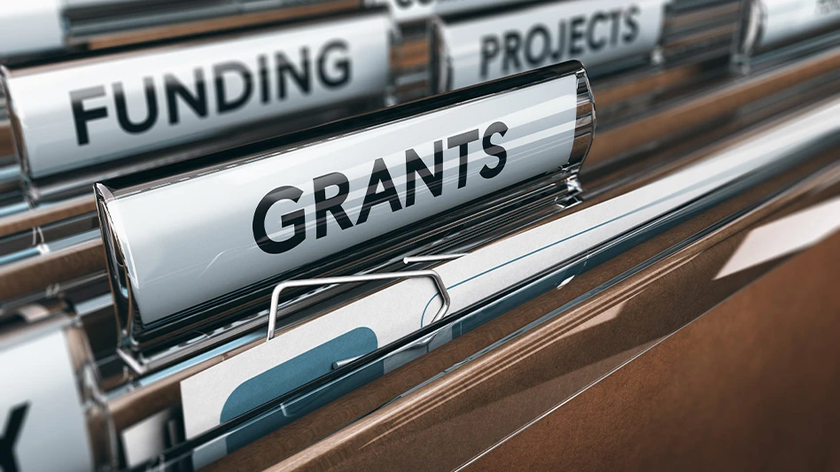A closeup of file folders that read "grants" and "funding."