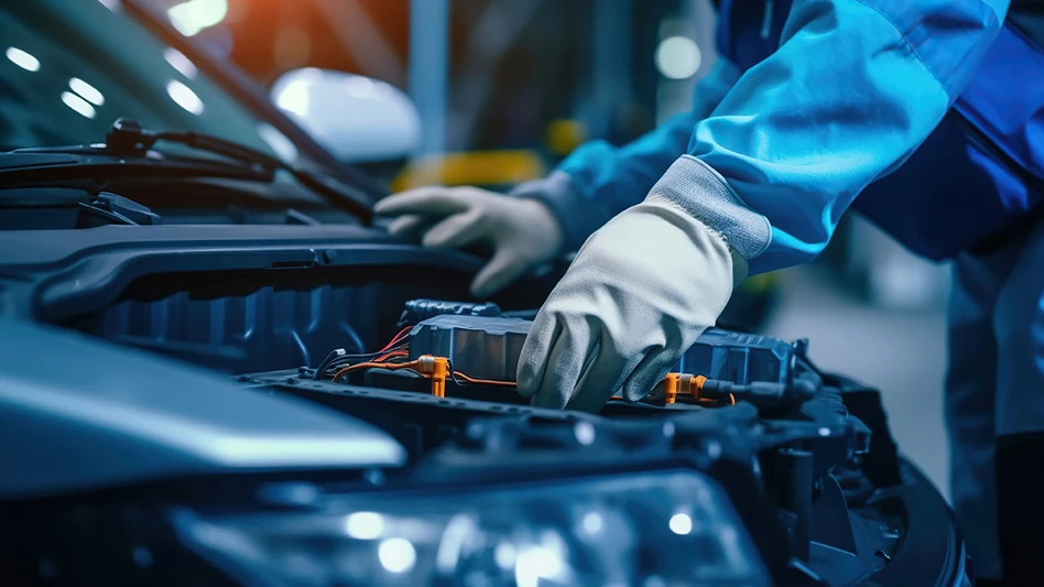A worker services an electric vehicle battery.
