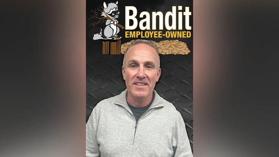 a smiling balding man with the Bandit logo behind him