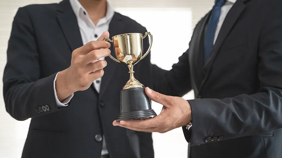 the hands of an employee receiving a golden cup reward