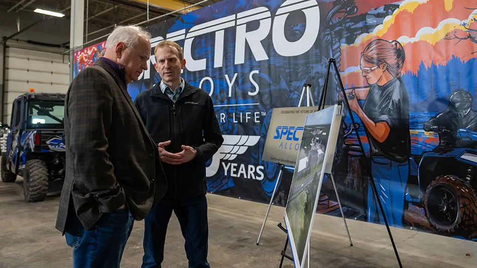 two men stand talking in front of a mural at Spectro Alloys Rosemount, Minnesota, location