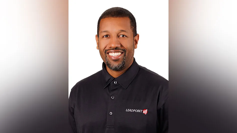 a smiling Black man with facial hair in a leadpoint button-up