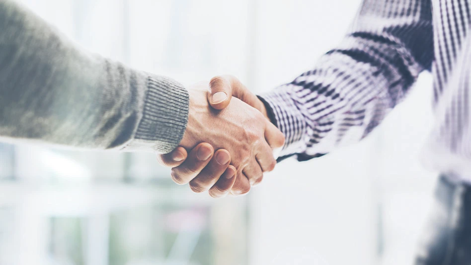 Two businessmen shake hands.