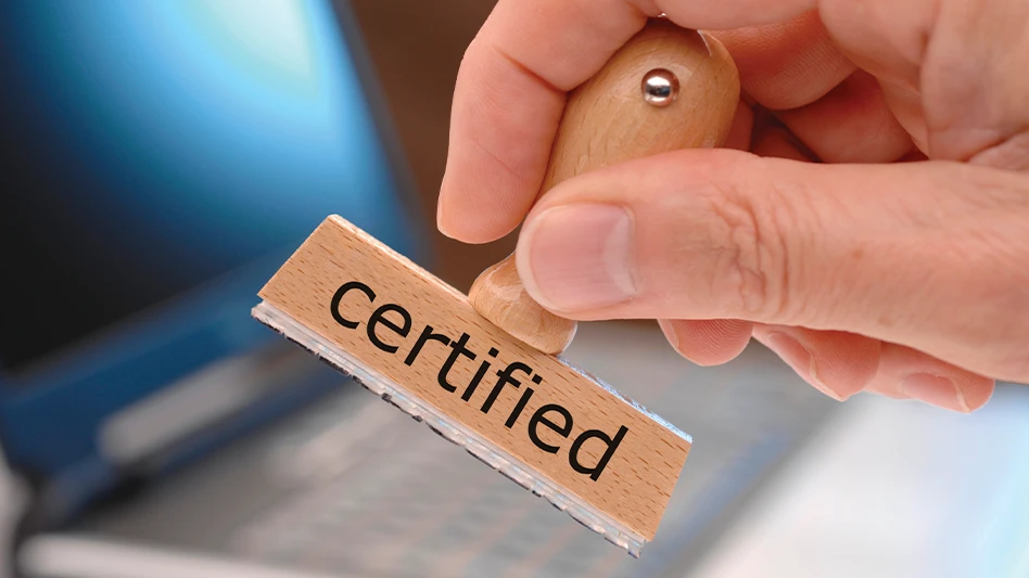 A hand holds a rubber stamp with the word "certification" printed on it.
