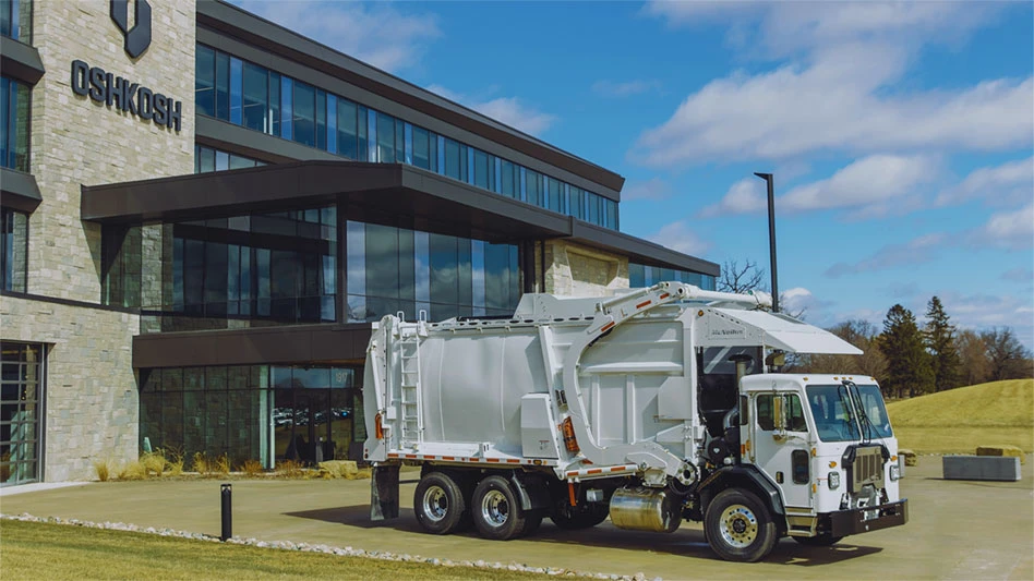 white McNeilus refuse and recycling collection vehicle outside of Oshkosh facility