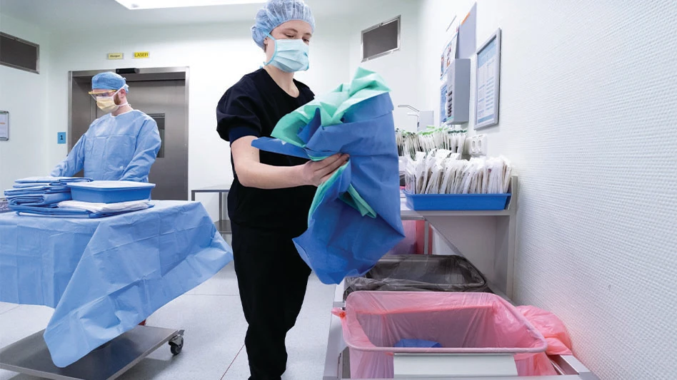 Two members of a hospital staff work in a hospital room.