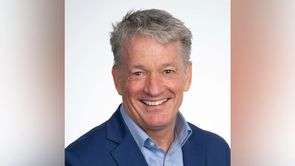 a smiling gray-haired man in a blue shirt and jacket