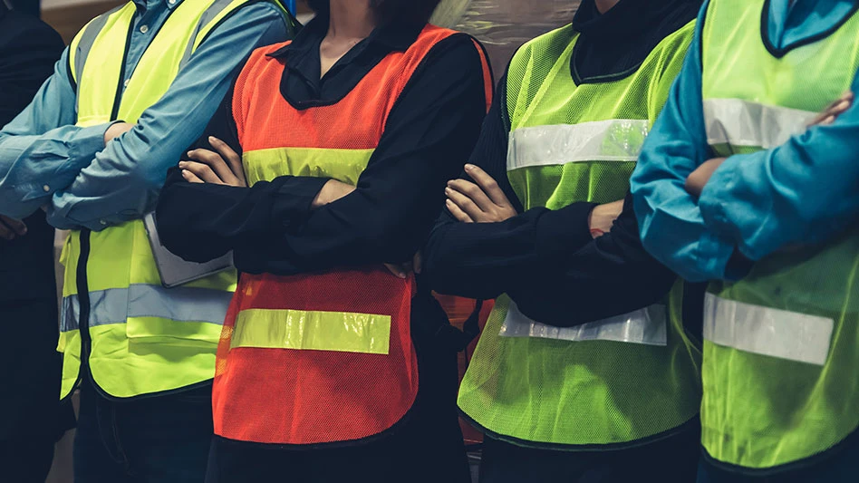 men and women in safety vests with their hands crossed in front of their chests