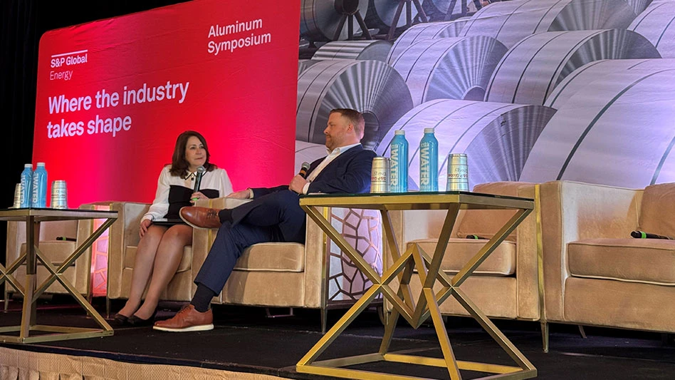 a woman and a man face each other seated on a stage with the S&P Global Energy logo behind them