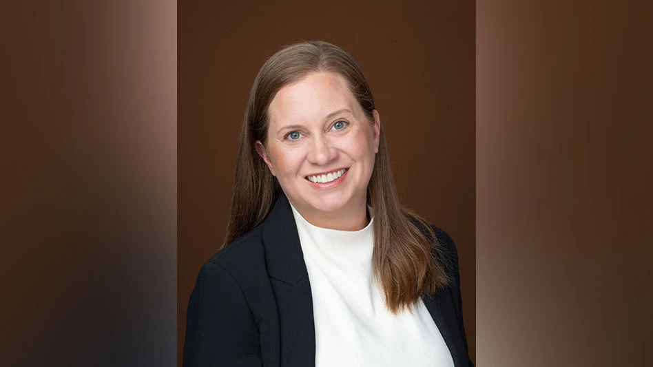 a smiling woman with brown hair wearing a white shirt and blue suit jacket