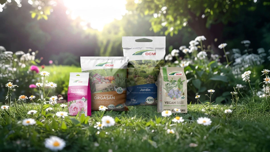 Bags of DCM fertilizer in a field with flowers