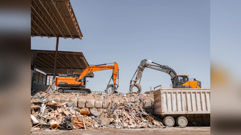 two excavators in construction and demolition debris