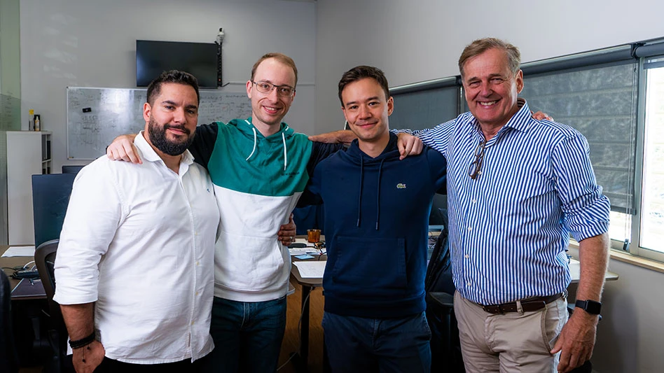 four men stand in an room