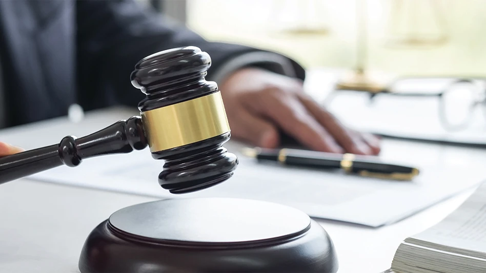 A man sitting at a table holding a gavel.