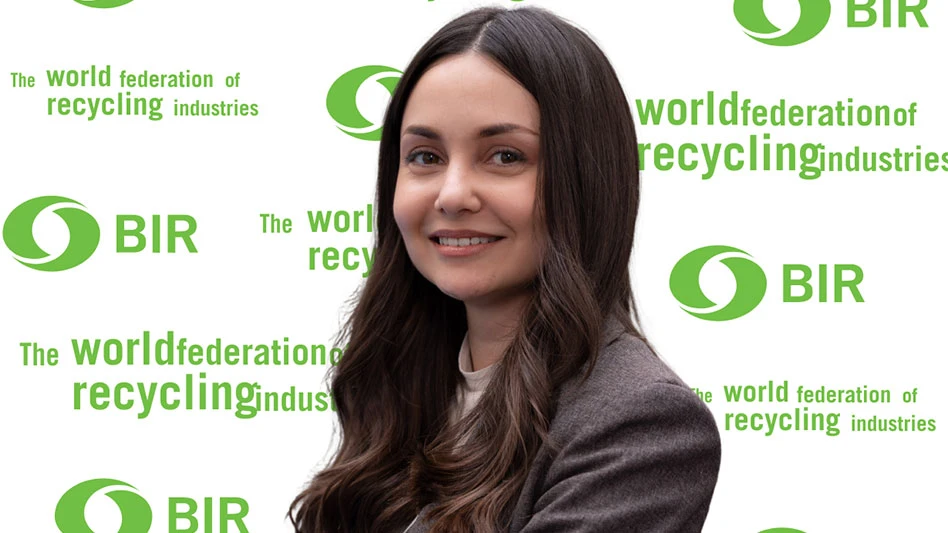 a smiling woman with long dark hair against a BIR stand and repeat